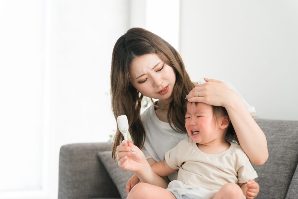 赤ちゃんの体温を測るお母さん