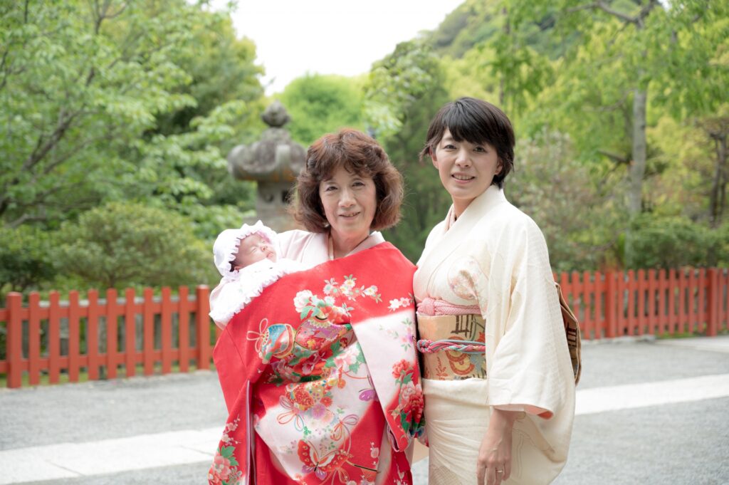 お宮参りをする家族と祖父母