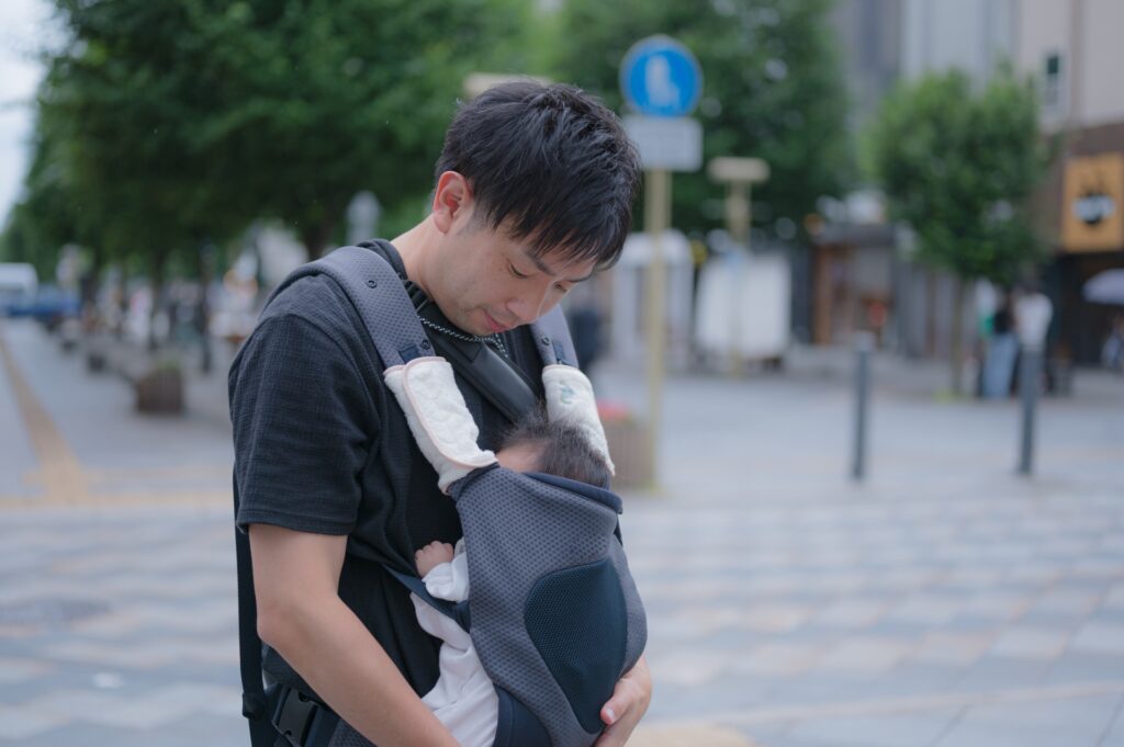 抱っこ紐で赤ちゃんを抱っこするパパ