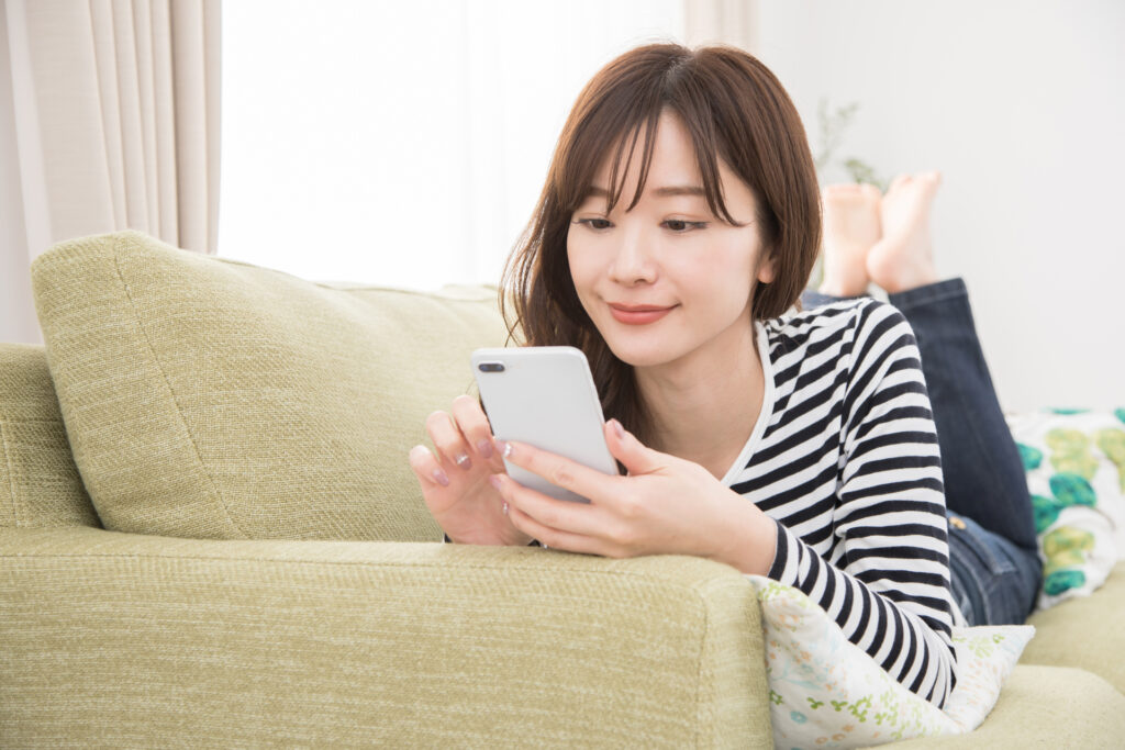 スマホで保育園に見学の予約電話をかける女性