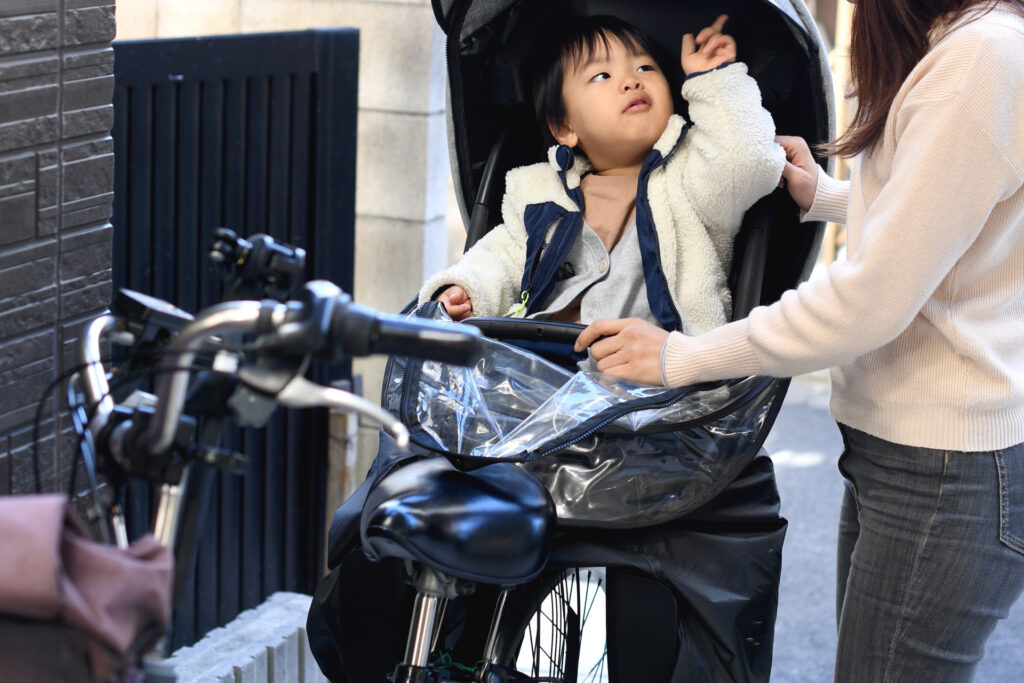 自転車の子ども乗せ座席に座る子ども