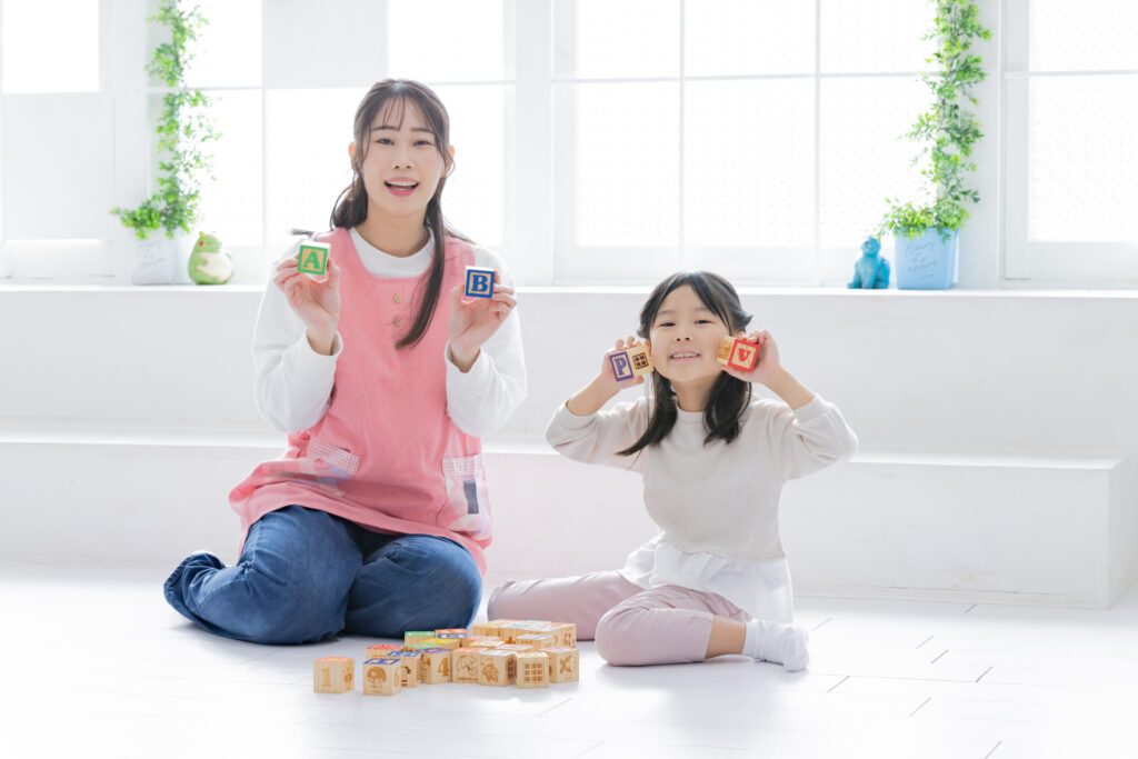 保育園の室内で遊ぶ子どもと保育士さん