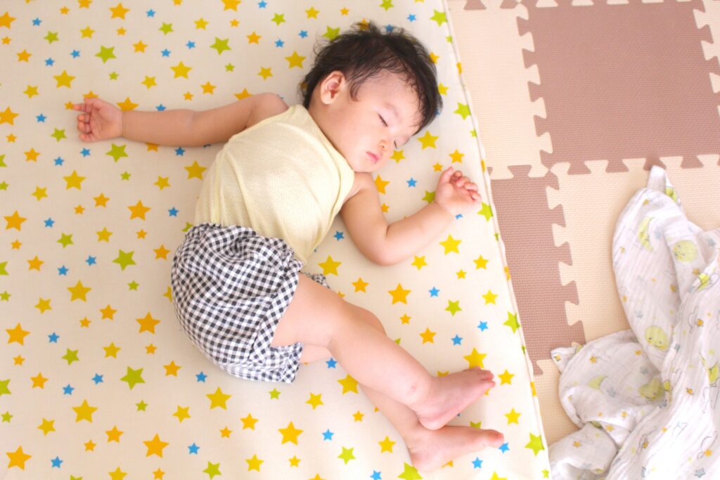 ベビーマットの上で眠る赤ちゃん