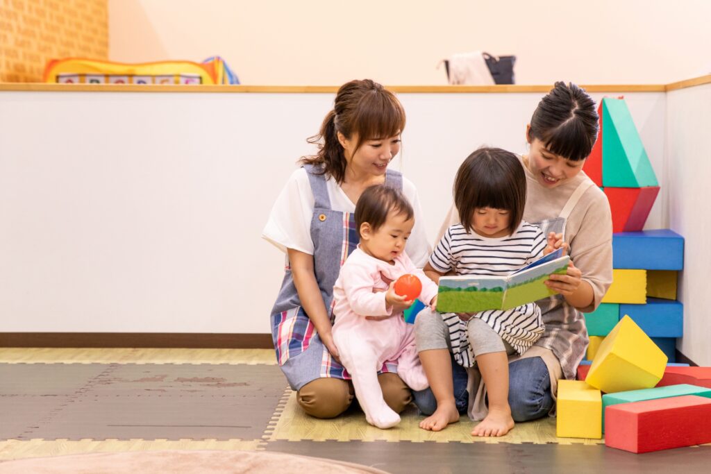 保育園で先生と遊ぶ子どもたち